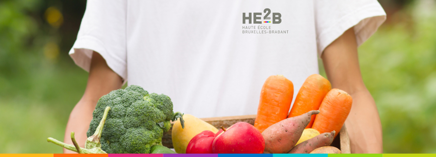 Étudiant avec des fruits et légumes pour l'Épicerie Partagée HE2B